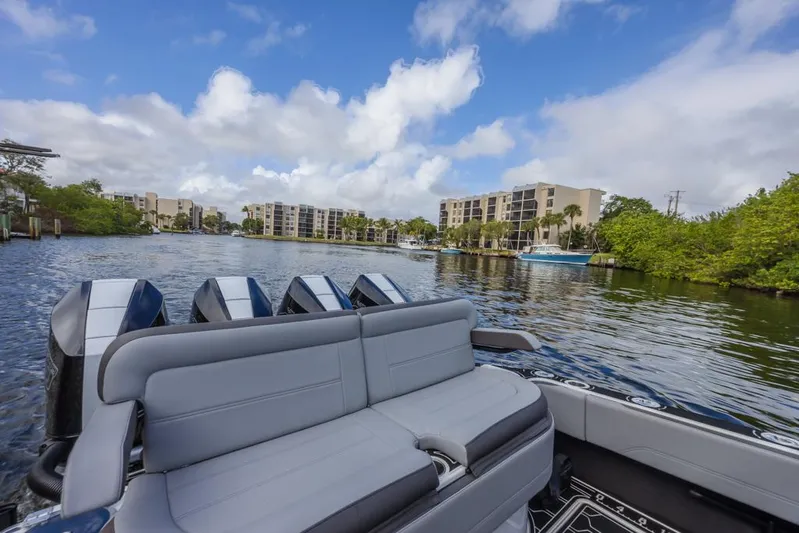  Yacht Photos Pics 2024 Nor-Tech 392 Super Fish boat on a scenic waterway with modern buildings.