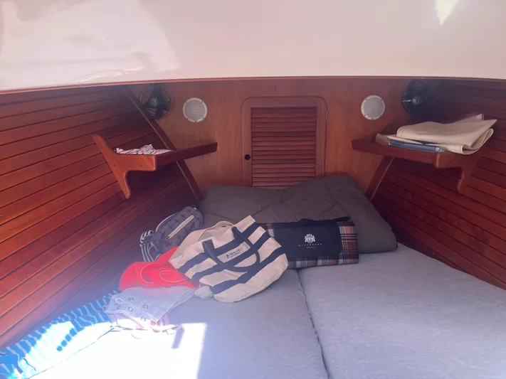  Yacht Photos Pics Cozy cabin interior of 1999 Hinckley Picnic boat with wooden paneling and storage shelves.