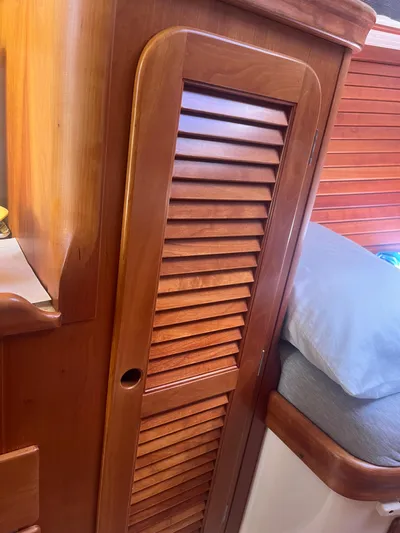  Yacht Photos Pics 1999 Hinckley Picnic boat interior with wooden louvered cabinet and bed.