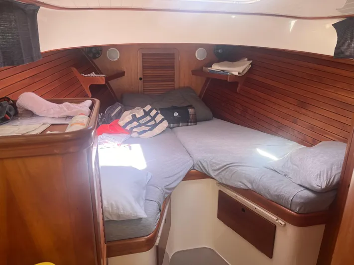  Yacht Photos Pics Cozy cabin interior of a 1999 Hinckley Picnic boat with wooden paneling and bedding.