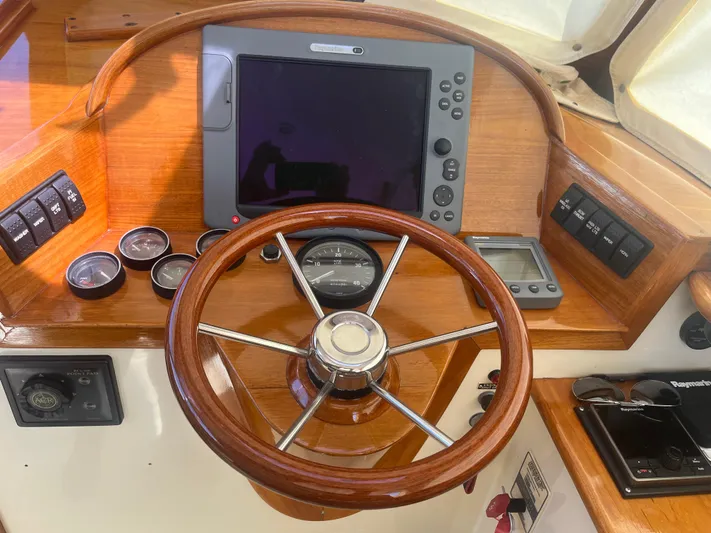  Yacht Photos Pics 1999 Hinckley Picnic boat helm with wooden steering wheel and navigation instruments.