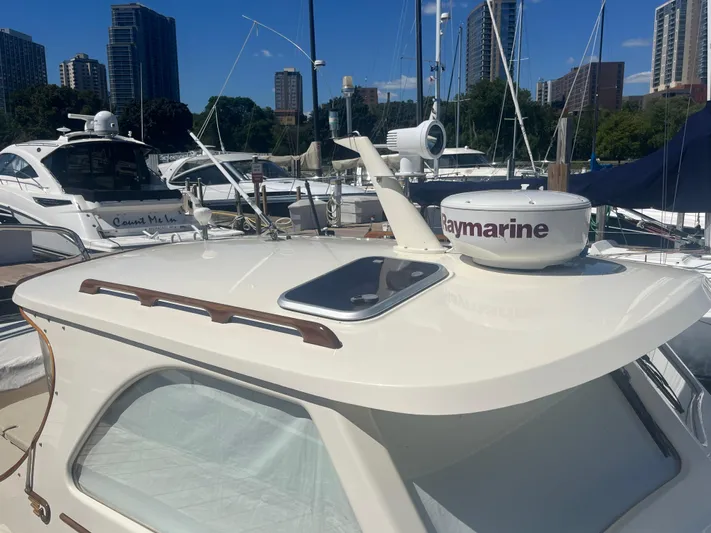  Yacht Photos Pics 1999 Hinckley Picnic boat docked at marina with city skyline in background.