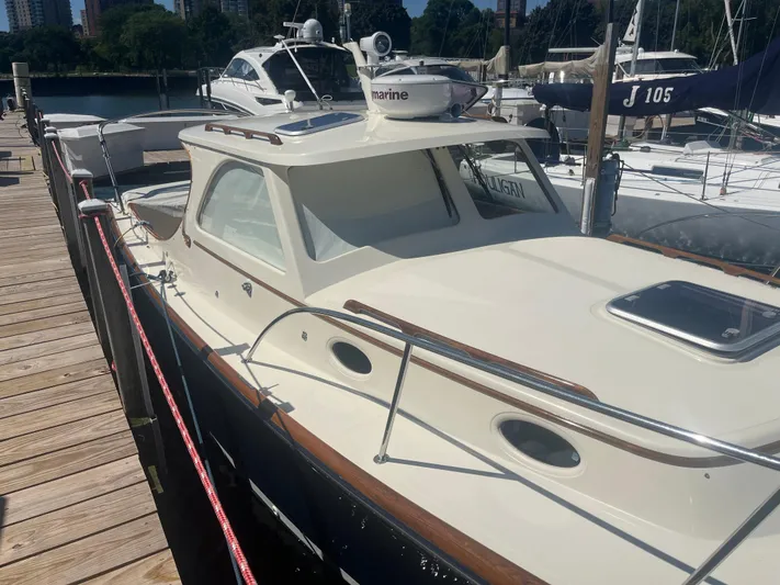  Yacht Photos Pics 1999 Hinckley Picnic boat docked at marina, showcasing classic design and elegant features.