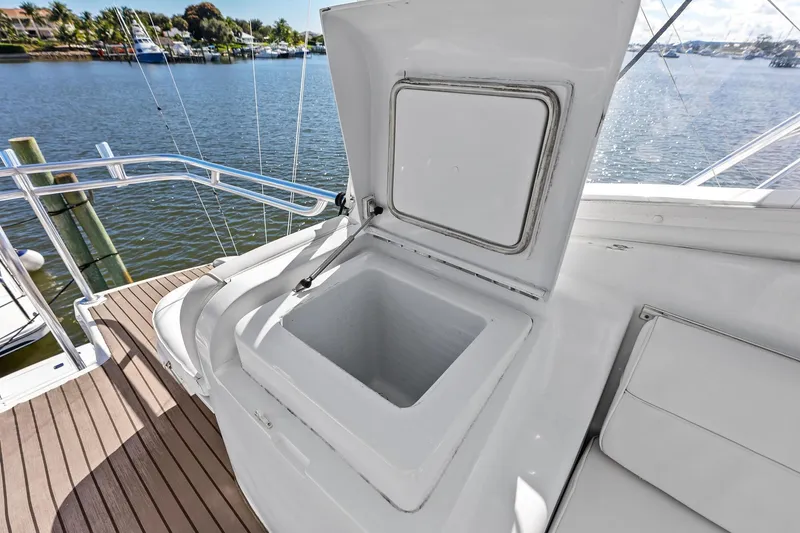 Bombshell Yacht Photos Pics Open storage compartment on 2003 Hatteras 65 Convertible yacht, docked by a scenic waterfront.
