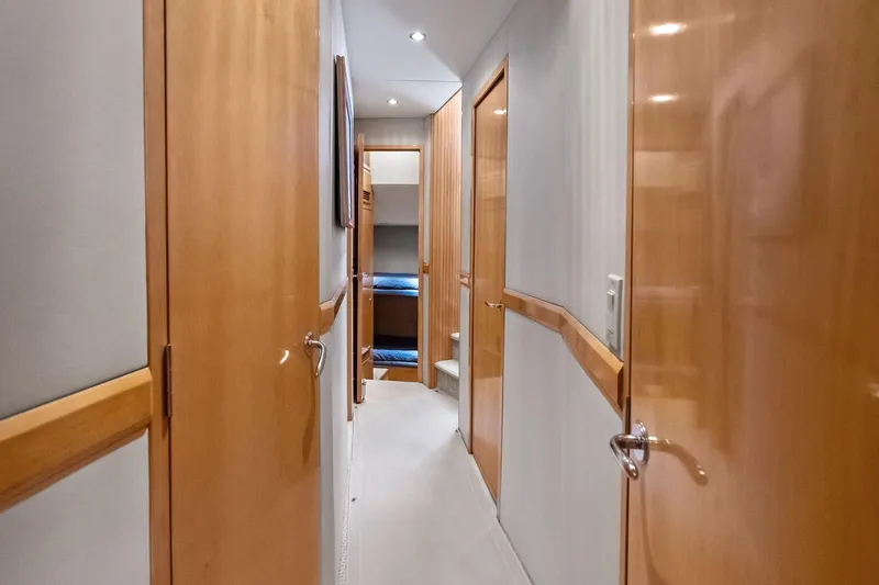Bombshell Yacht Photos Pics Hallway inside 2003 Hatteras 65 Convertible yacht with wooden doors and cozy lighting.