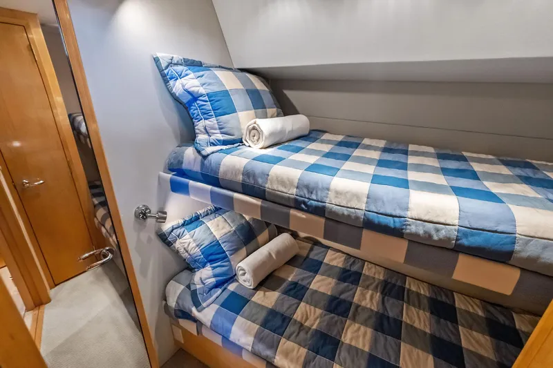 Bombshell Yacht Photos Pics Bunk beds with blue checkered bedding in 2003 Hatteras 65 Convertible yacht cabin.