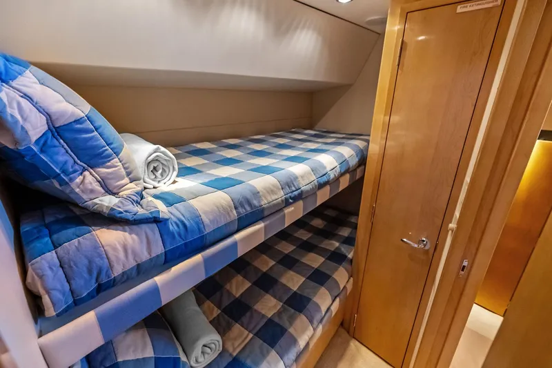 Bombshell Yacht Photos Pics Bunk beds with blue checkered bedding in 2003 Hatteras 65 Convertible yacht cabin.