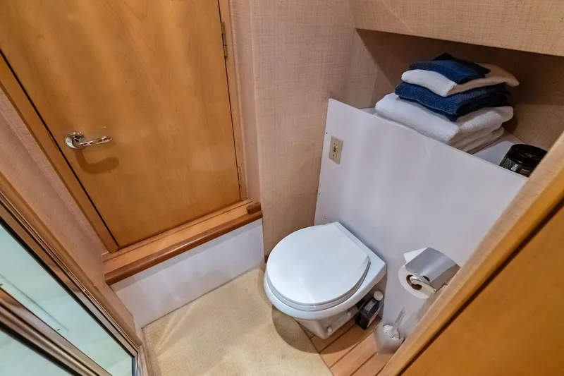 Bombshell Yacht Photos Pics Bathroom interior of 2003 Hatteras 65 Convertible yacht with toilet and towels.