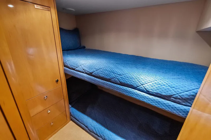 Bombshell Yacht Photos Pics Bunk beds with blue bedding in 2003 Hatteras 65 Convertible yacht cabin.