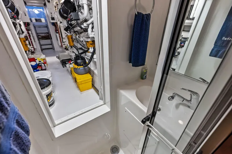 Bombshell Yacht Photos Pics Engine room and bathroom of 2003 Hatteras 65 Convertible yacht, showcasing equipment and amenities.