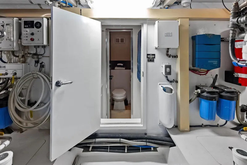 Bombshell Yacht Photos Pics Engine room of 2003 Hatteras 65 Convertible yacht with visible equipment and open door.