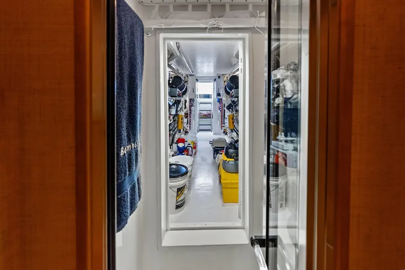 Bombshell Yacht Photos Pics Engine room of 2003 Hatteras 65 Convertible yacht, featuring organized storage and equipment.