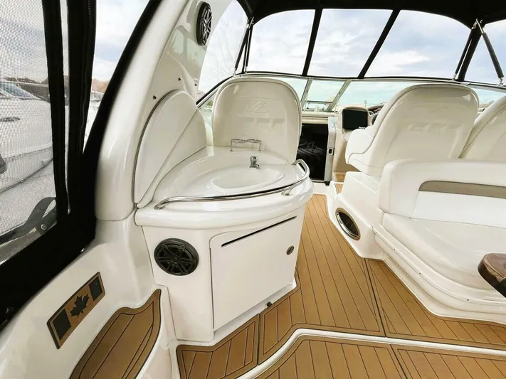  Yacht Photos Pics 2005 Sea Ray 340 Sundancer interior with seating and sink, featuring elegant wood flooring.