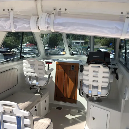 Intermission Yacht Photos Pics Interior of a 2006 Back Cove 29 boat with helm and seating area.