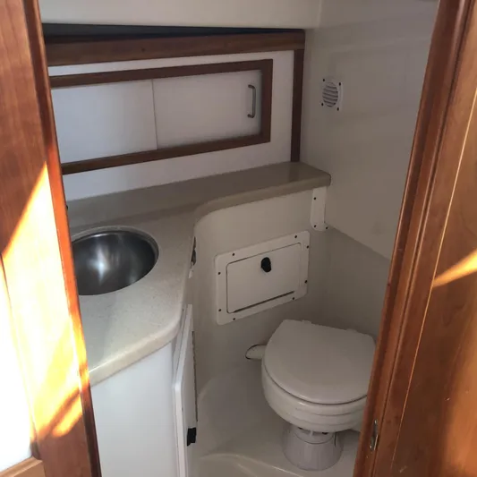 Intermission Yacht Photos Pics 2006 Back Cove 29 boat bathroom with sink, toilet, and storage cabinet.