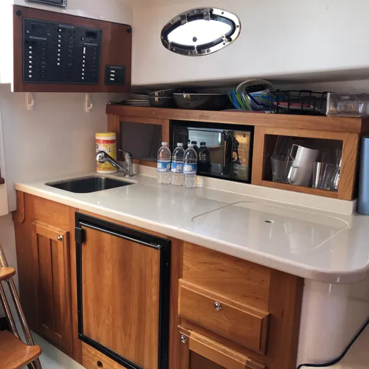 Intermission Yacht Photos Pics 2006 Back Cove 29 boat interior kitchen with sink, wooden cabinets, and countertop.