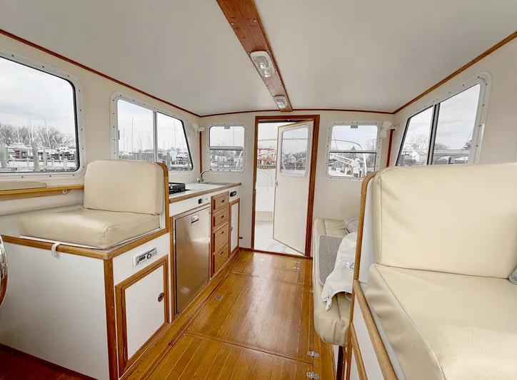 Riverwind Yacht Photos Pics Interior of 2008 Eastern Casco Bay 31 boat with wood flooring and beige seating.