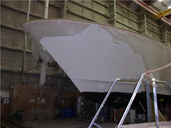 Yacht Photos Pics 2022 Westport boat hull in a workshop, partially covered, awaiting further construction.