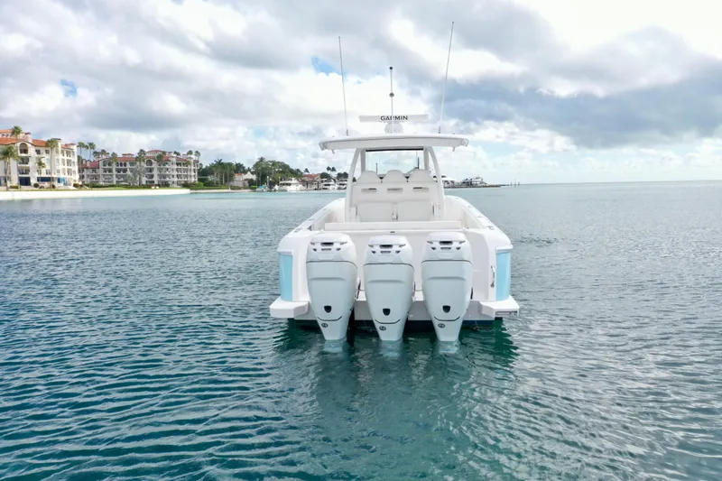  Yacht Photos Pics 2022 Intrepid 407 Nomad SE boat with four engines on calm water, luxury waterfront homes in background.