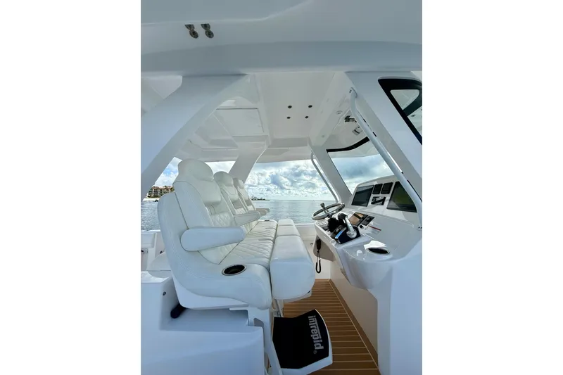  Yacht Photos Pics Interior view of 2022 Intrepid 407 Nomad SE boat with luxurious seating and modern controls.