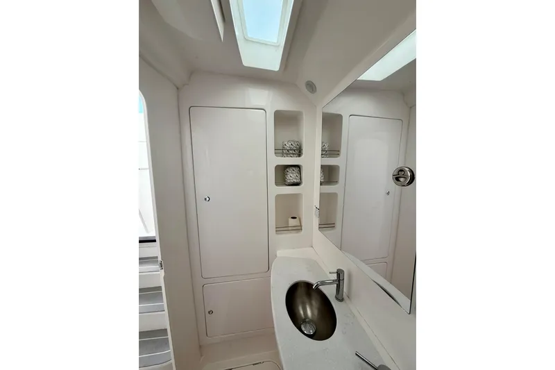  Yacht Photos Pics 2022 Intrepid 407 Nomad SE bathroom with modern sink, mirror, and storage shelves.