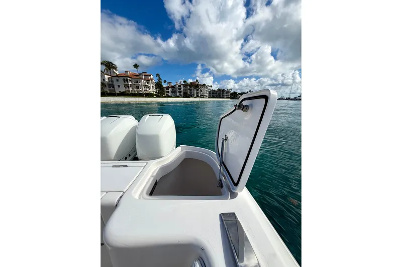  Yacht Photos Pics 2022 Intrepid 407 Nomad SE boat with open hatch, ocean view, and coastal buildings.