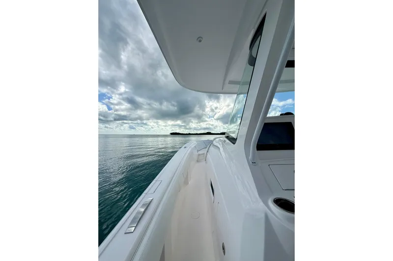  Yacht Photos Pics 2022 Intrepid 407 Nomad SE boat cruising on calm waters under cloudy sky.