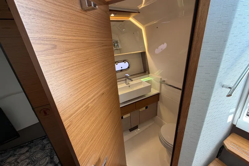 Marilee Yacht Photos Pics Luxurious bathroom interior of 2024 Tiara Yachts 43 LS, featuring modern fixtures and wood accents.