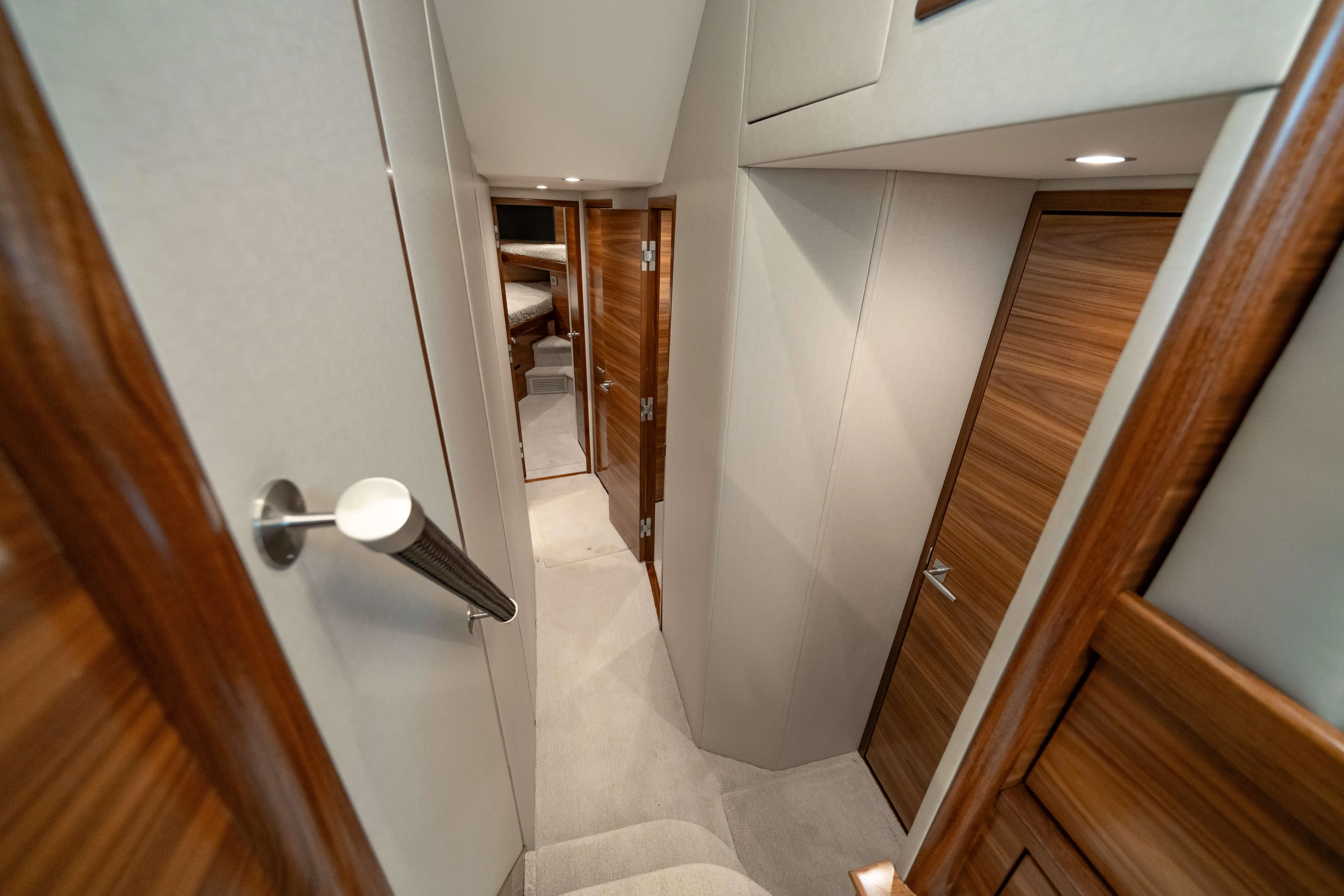 2026 Viking 50c Yacht Photos Pics Interior hallway of 2026 Viking 50 Convertible yacht with wooden doors and carpeted floor.