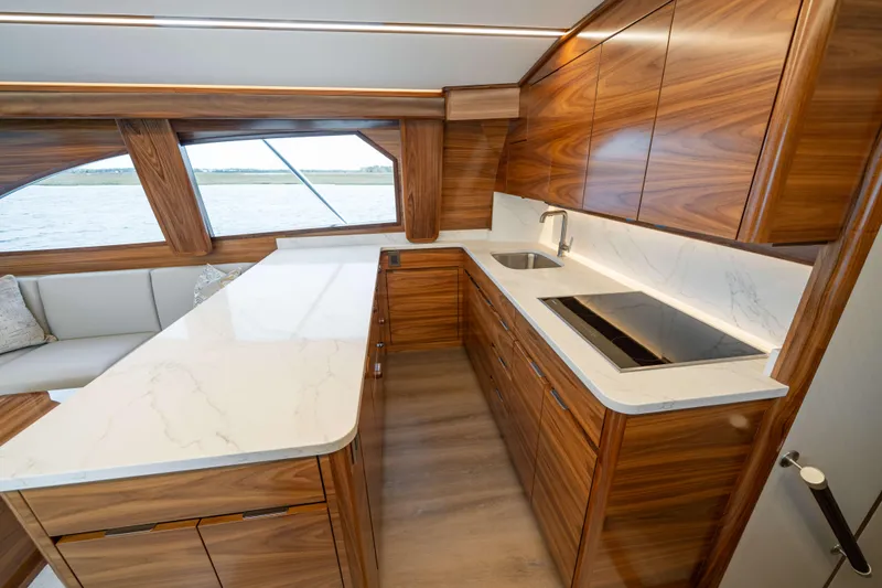 2026 Viking 50c Yacht Photos Pics Luxurious kitchen interior of 2026 Viking 50 Convertible yacht with wood cabinetry and marble countertops.