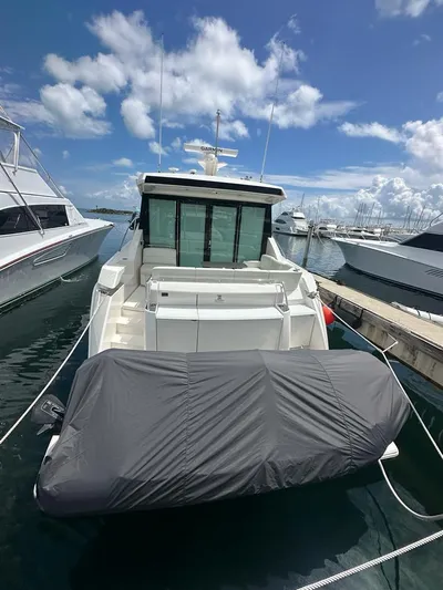  Yacht Photos Pics 2023 Tiara Yachts C49 Coupe docked at marina under blue sky.