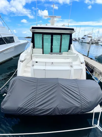  Yacht Photos Pics 2023 Tiara Yachts C49 Coupe docked at marina, rear view with covered equipment.