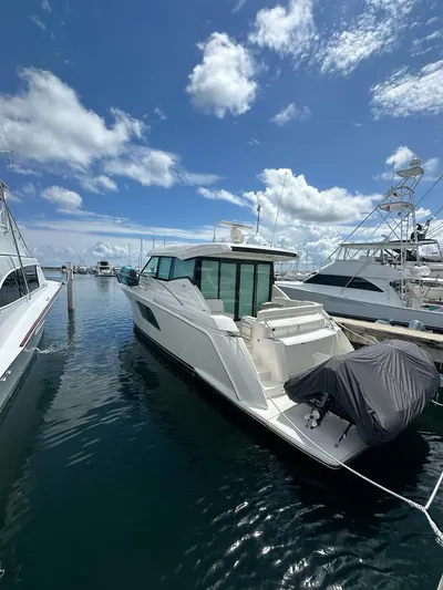 Yacht Photos Pics 2023 Tiara Yachts C49 Coupe docked under a bright blue sky.
