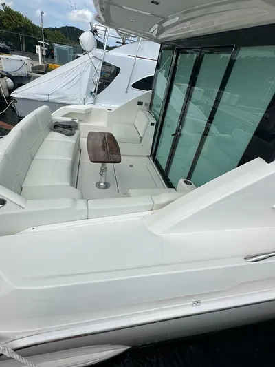  Yacht Photos Pics 2023 Tiara Yachts C49 Coupe, elegant deck with seating and table, docked at marina.