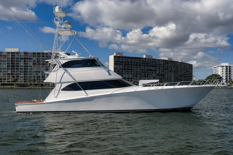 Benedetta Yacht Photos Pics 2012 Viking 70 Enclosed Bridge yacht cruising near modern waterfront buildings.