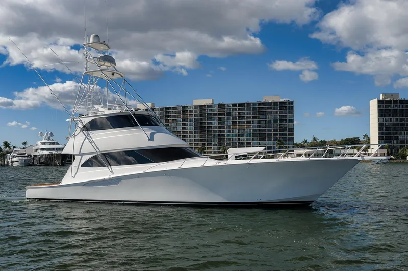 Benedetta Yacht Photos Pics 2012 Viking 70 Enclosed Bridge yacht on water, with cityscape background.