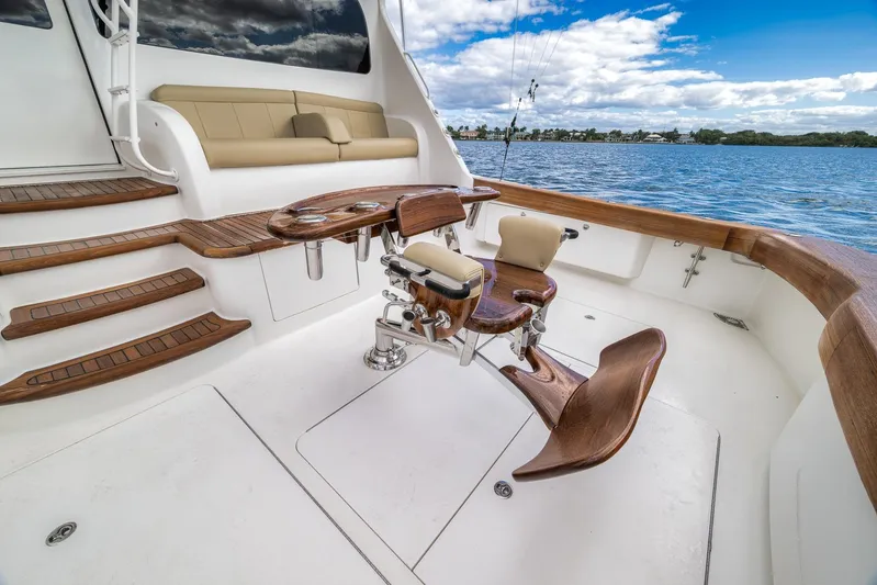 Benedetta Yacht Photos Pics Luxurious 2012 Viking 70 Enclosed Bridge yacht deck with fishing chair and scenic water view.
