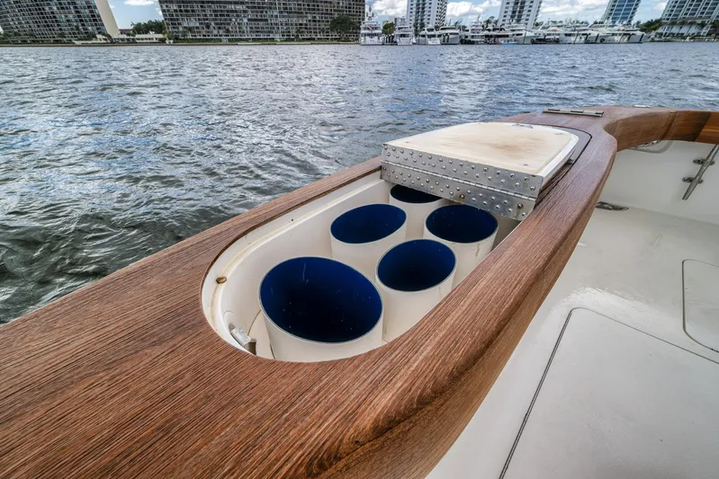 Benedetta Yacht Photos Pics 2012 Viking 70 Enclosed Bridge yacht with rod holders and cutting board, docked by waterfront buildings.