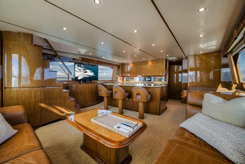 Benedetta Yacht Photos Pics Luxurious interior of 2012 Viking 70 Enclosed Bridge yacht with elegant wood finishes and seating.