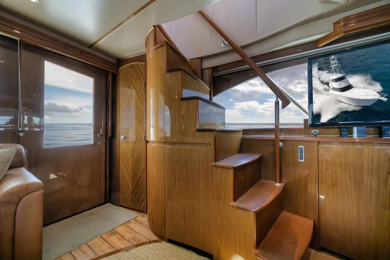Benedetta Yacht Photos Pics Luxurious interior of 2012 Viking 70 Enclosed Bridge yacht with wooden staircase and ocean view.
