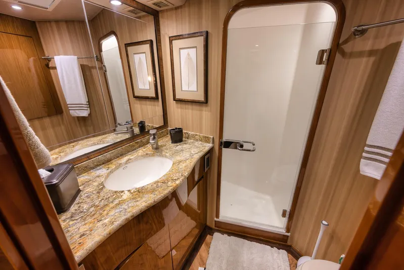 Benedetta Yacht Photos Pics Luxurious bathroom in 2012 Viking 70 Enclosed Bridge yacht with granite countertop and glass shower.