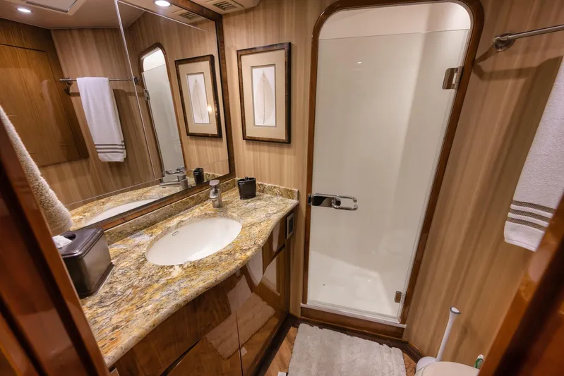 Benedetta Yacht Photos Pics Luxurious bathroom in 2012 Viking 70 Enclosed Bridge yacht with granite countertop and glass shower.