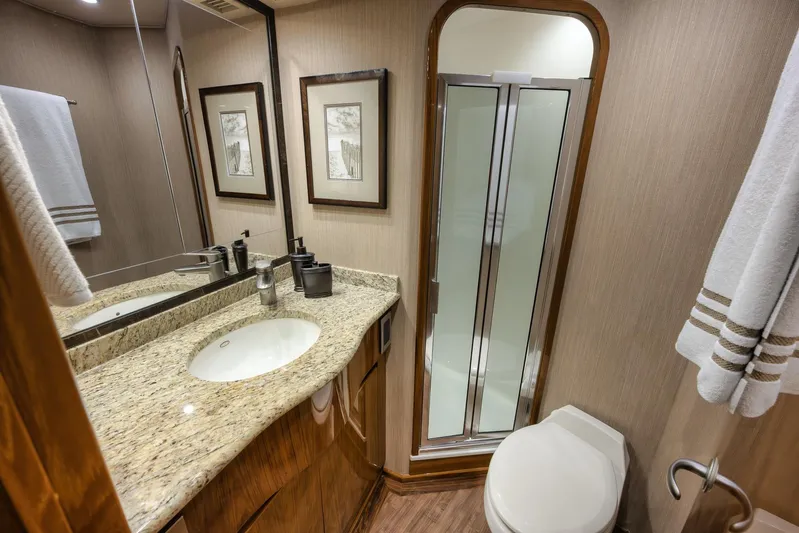 Benedetta Yacht Photos Pics Luxurious bathroom in 2012 Viking 70 Enclosed Bridge yacht with granite countertop and shower.