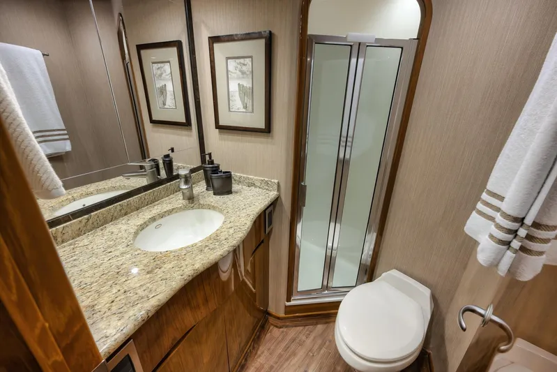 Benedetta Yacht Photos Pics Luxurious bathroom in 2012 Viking 70 Enclosed Bridge yacht with granite countertop and shower.