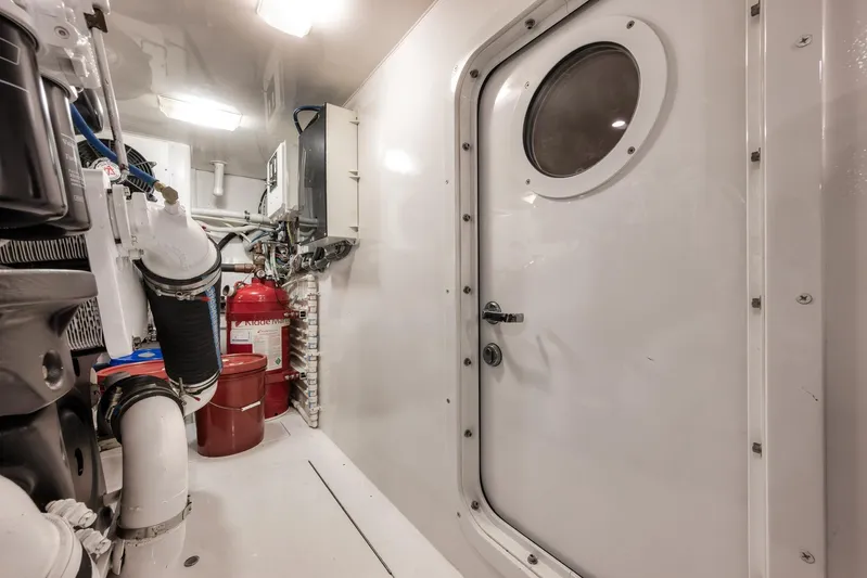 Benedetta Yacht Photos Pics Engine room of 2012 Viking 70 Enclosed Bridge yacht, featuring equipment and secure door.