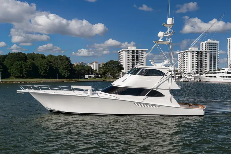 Benedetta Yacht Photos Pics 2012 Viking 70 Enclosed Bridge yacht cruising near modern waterfront buildings.