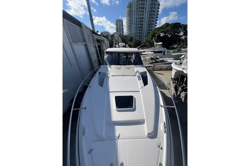  Yacht Photos Pics 2015 Regal 35 Sport Coupe boat docked near high-rise buildings and trees.