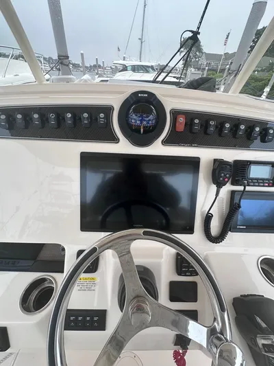  Yacht Photos Pics 2022 Grady-White Canyon 326 boat dashboard with steering wheel and navigation equipment.