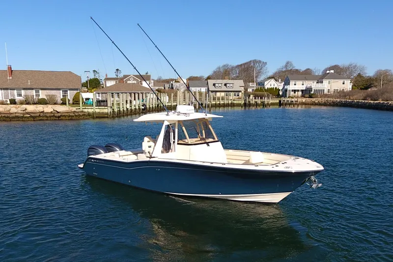  Yacht Photos Pics 2022 Grady-White Canyon 326 boat on calm water near coastal homes.