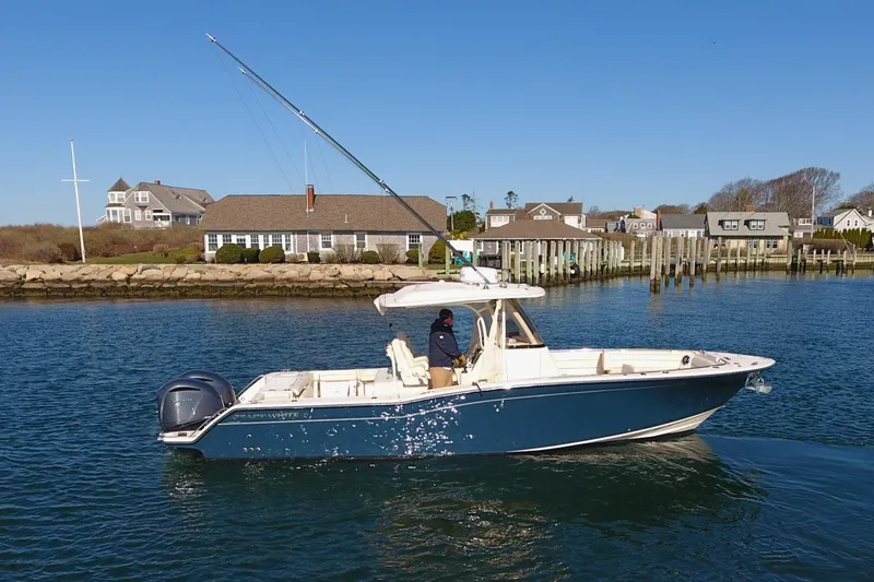  Yacht Photos Pics 2022 Grady-White Canyon 326 boat cruising in a scenic coastal area.